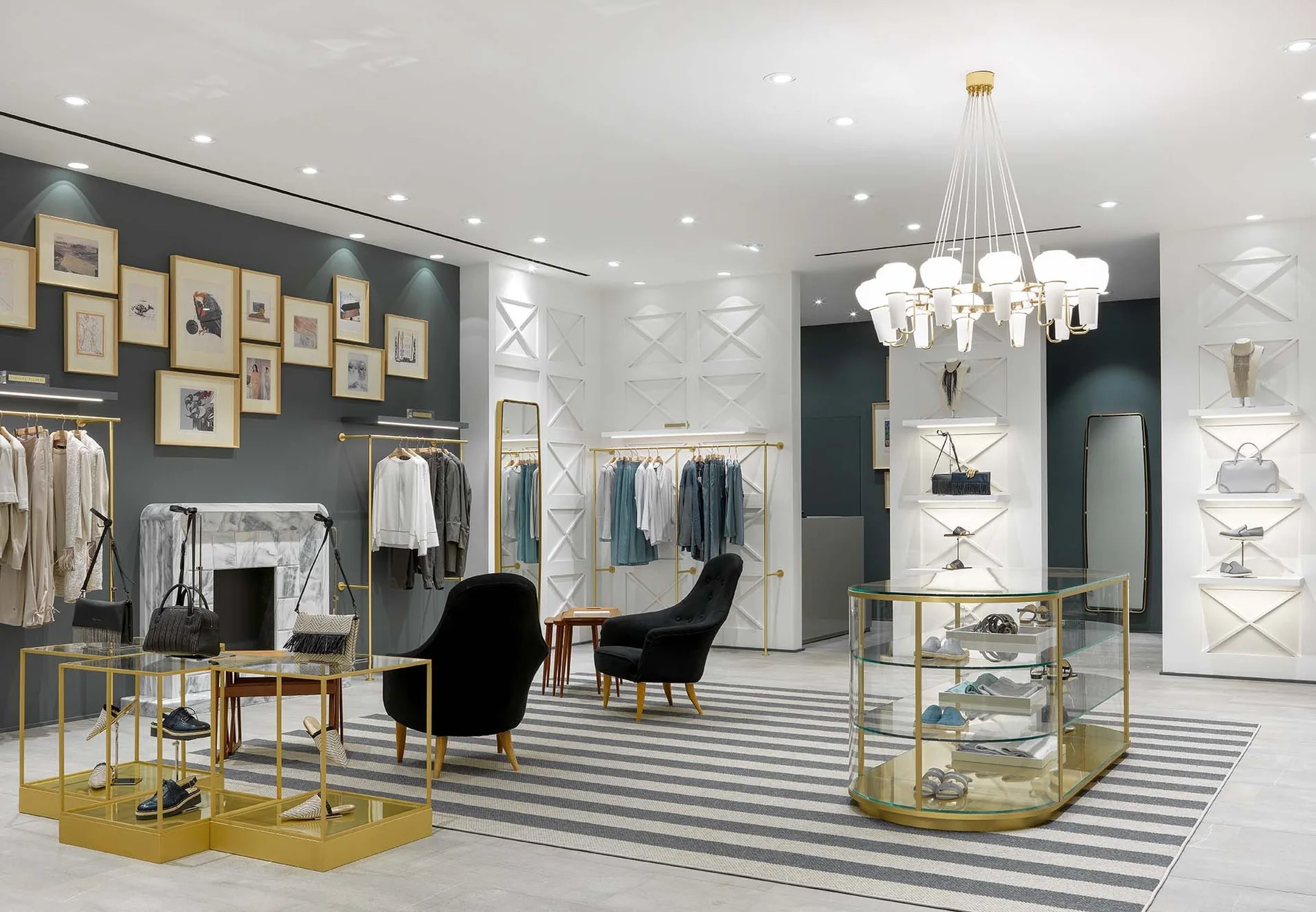 Zona de espera de una boutique en Moscú, Rusia, con sillones negros, mesas doradas y una pared de arte.