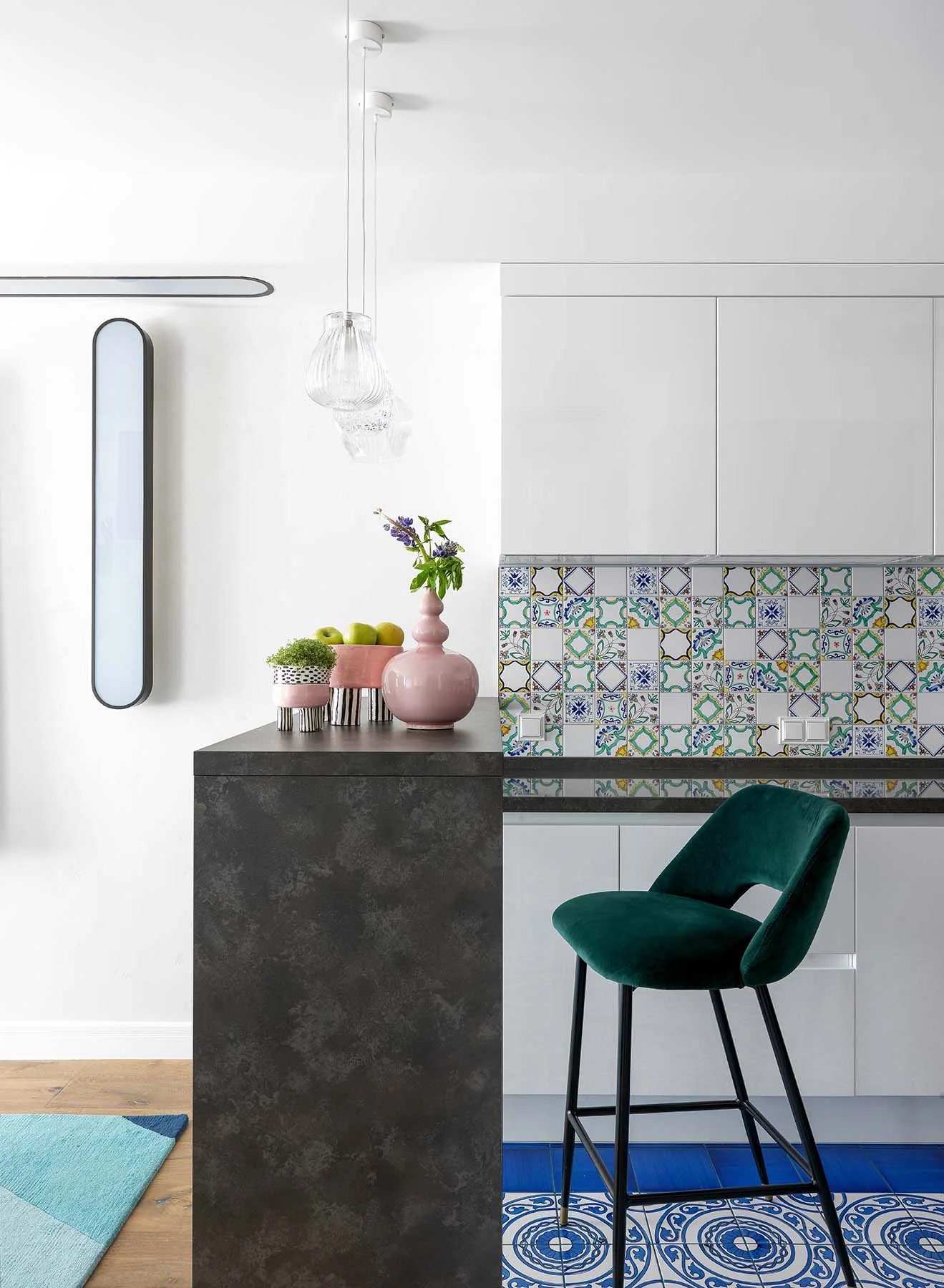 Cocina blanca de un apartamento en Moscú con taburete verde, azulejos azules y jarrones rosas.