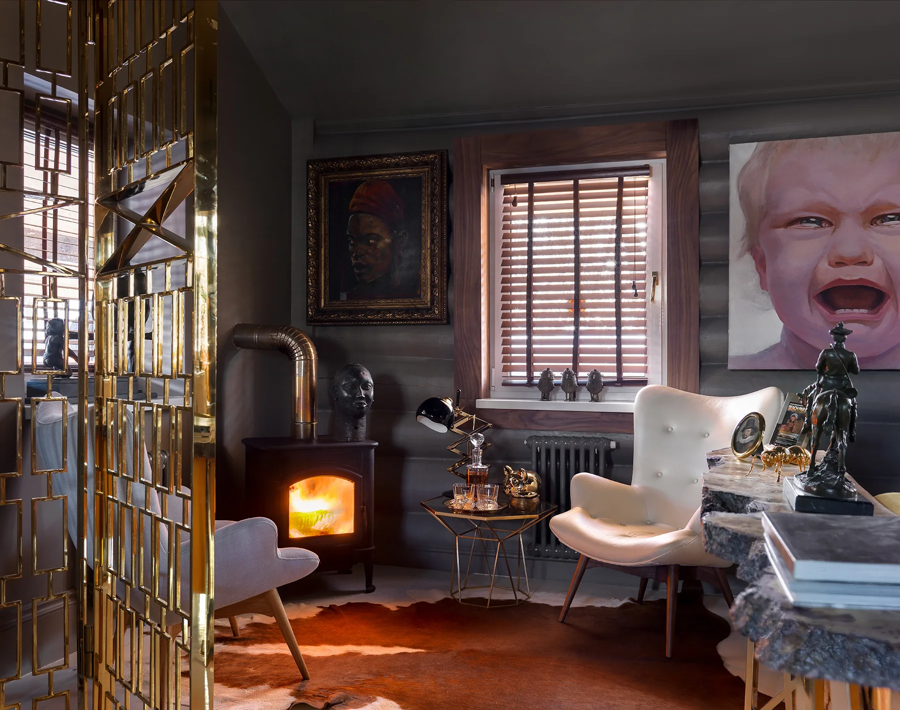 Rincón de una casa en Moscú con estufa encendida, sillones, retrato y esculturas.